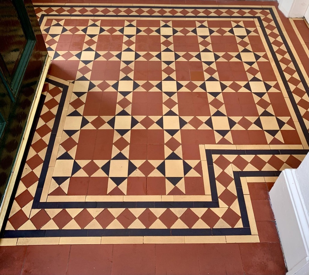 New Victorian geometric tile floor installation in a period property in Pollokshields, Glasgow, featuring traditional red, cream and black tiles with decorative borders.