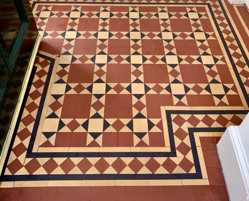 New Victorian geometric tile floor installation in a period property in Pollokshields, Glasgow, featuring traditional red, cream and black tiles with decorative borders.